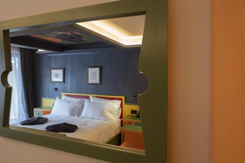a mirror reflection of a bed in a room at Locanda degli Artisti Art Hotel in Canazei