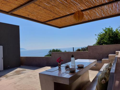 a patio with a table and a view of the ocean at Athena s House in Platia Ammos