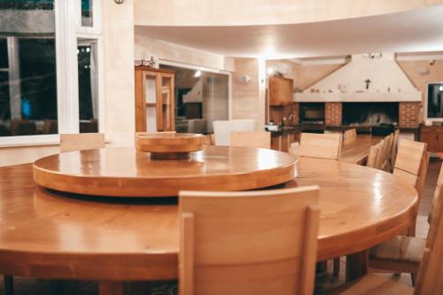 a large wooden table with chairs and a kitchen at Resort Trcol in Novalja