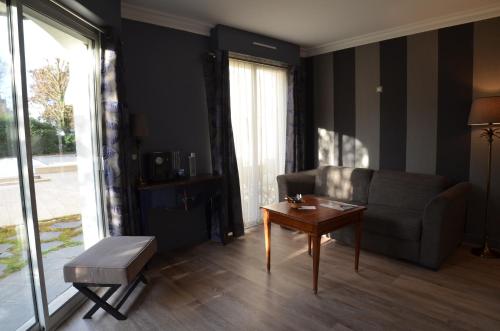 a living room with a couch and a table at Villa Augeval Hôtel de charme & Spa in Deauville
