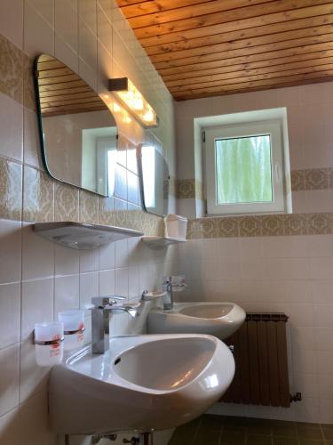 Baño con 2 lavabos y espejo en Wiesenhof, en Berwang