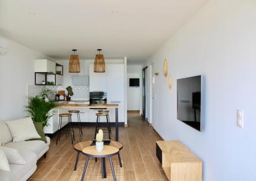 un salon et une cuisine avec un canapé et une table dans l'établissement LE PALM - 1 ère ligne vue mer - Exceptionnel P2 cabine, à La Grande Motte