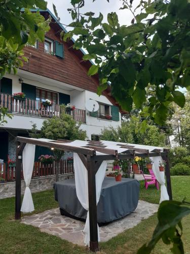 a pergola with a table in front of a house at B&B Villa Guido in Spezzano della Sila