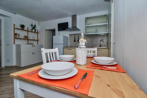 a kitchen with a table with bowls and plates on it at B&B Sea and Garden in Orbetello