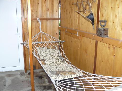a hammock in a room with a wooden wall at Guesthouse Geto in Belogradchik
