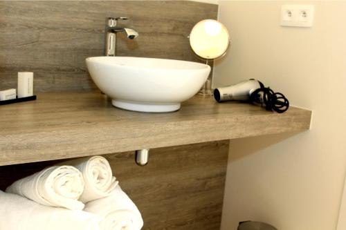 uma casa de banho com um balcão com um lavatório e toalhas em B&B Laurus em Ypres