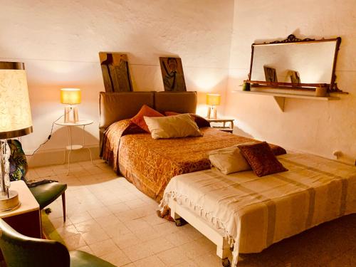 Un dormitorio con una cama y un espejo en la pared. en Casette rosse nel borgo medievale di Fossanova, en Latina
