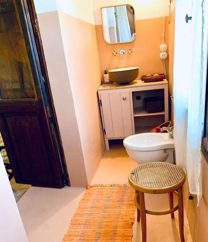 Un baño con inodoro, lavabo y espejo. en Casette rosse nel borgo medievale di Fossanova, en Latina