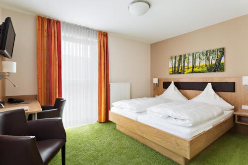 - une chambre avec un lit, un bureau et une fenêtre dans l'établissement Hotel Sixt, à Rohr