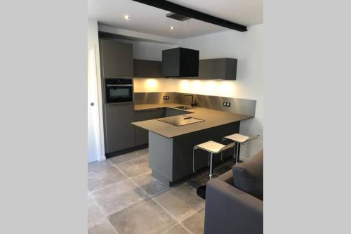 une cuisine avec un canapé, une table et un comptoir dans l'établissement Les chambres Berguoises Duplex calme au coeur de Bergues, à Bergues