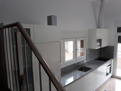 a kitchen with a counter top and a staircase at Andreamar in Cambados
