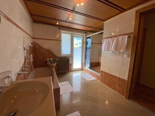 a large bathroom with a tub and a sink at Stammhaus im Hotel Alpine Palace in Saalbach Hinterglemm