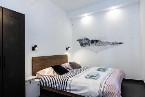 a bedroom with a bed and a painting on the wall at Andriana House in Šibenik