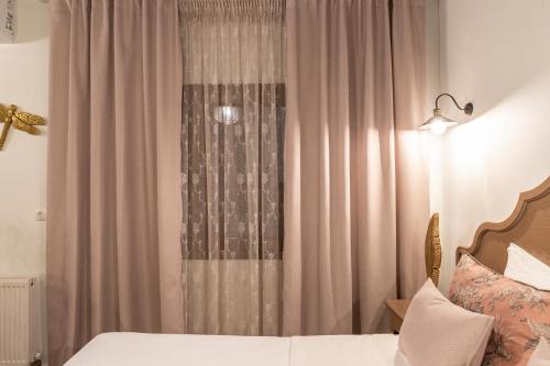 a bedroom with a bed and a window with curtains at Villa La Varik 3 in Litochoro