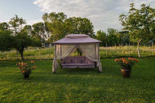 a bed in a gazebo in a field with two flowers at Villa La Varik 3 in Litochoro