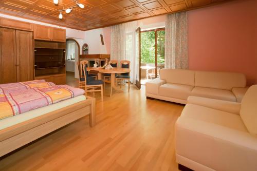 a bedroom with a bed and a living room at Appartement - Pension Adlerhorst in Velden am Wörthersee