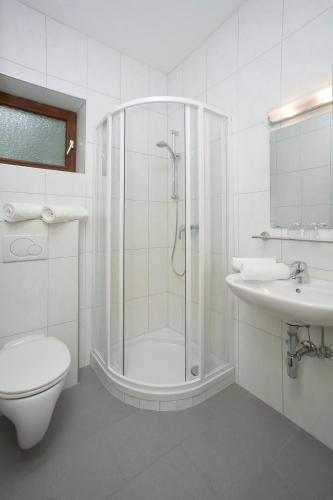 a bathroom with a shower and a toilet and a sink at Appartement - Pension Adlerhorst in Velden am Wörthersee