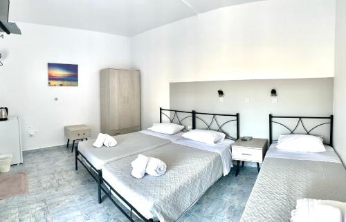 a bedroom with two beds with white pillows on them at Kedros Rooms in Prasonisi