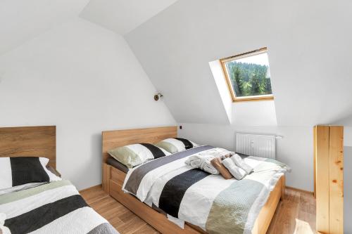 a bedroom with two beds and a window at Rezidence Rokytnice in Rokytnice nad Jizerou