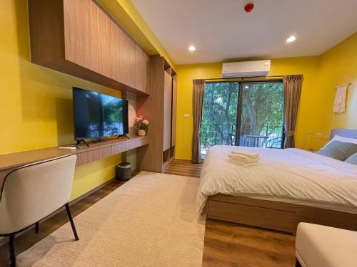 a bedroom with a large bed and a flat screen tv at Getway at Lahabana huahin in Hua Hin