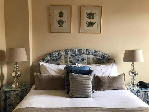 a bedroom with a bed with pillows and two lamps at The Windsor Town House in Bath