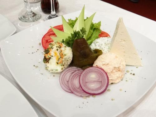 a plate of food with vegetables on a table at Стаи за гости The Old House in Velingrad