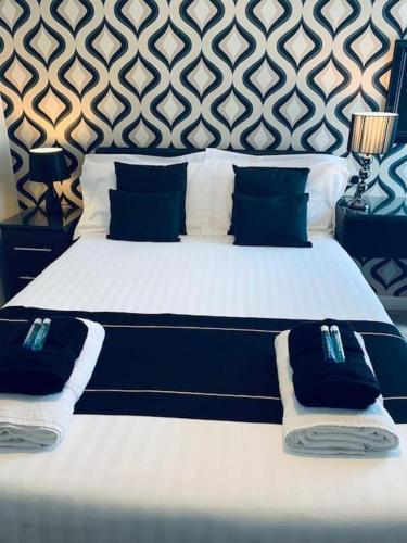a large bed with blue and white sheets and pillows at Bamford House Hotel in Blackpool