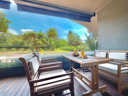a patio with a wooden table and chairs and a large window at PERLA Apartments in Budva