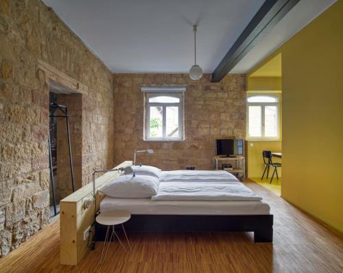 ein Schlafzimmer mit einem großen Bett in einer Ziegelwand in der Unterkunft Baumann & Müller in Walsheim