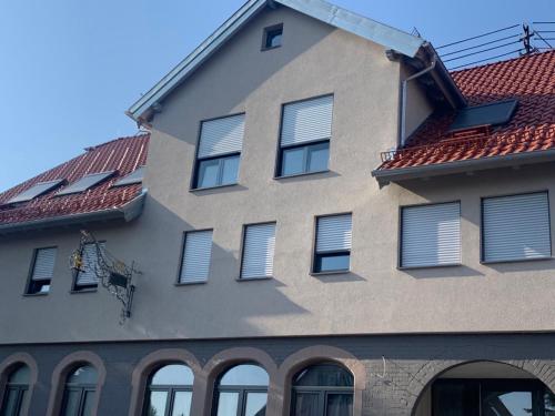 Straubenhardt的住宿－Gästehaus Hirsch 93，一座带窗户和红色屋顶的建筑
