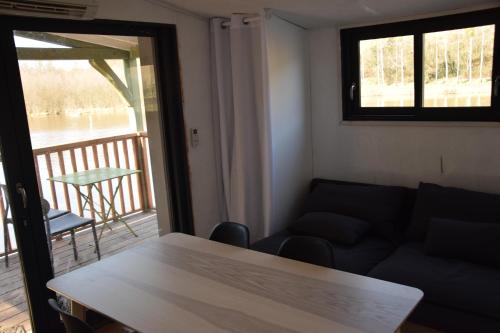 een woonkamer met een bank en een tafel en een balkon bij bateau du moulin girault in Panzoult