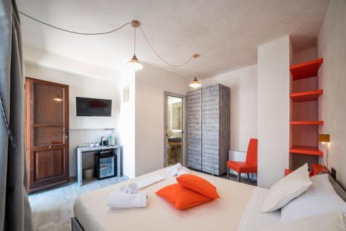 a bedroom with a bed with orange pillows on it at Domo Pro Vois in Orosei
