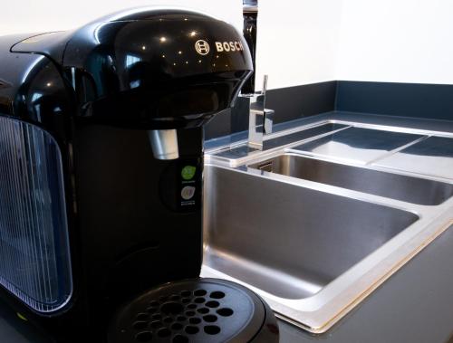 uma máquina de café ao lado de um lavatório de cozinha em Reading by Charles Hope em Reading
