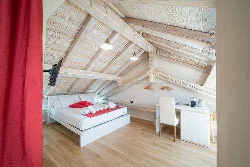 a bedroom with a white bed and a desk at Domo Pro Vois in Orosei
