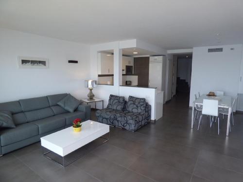 a living room with a couch and a table at Voramar 33A - Joana Attic in Port de Pollensa