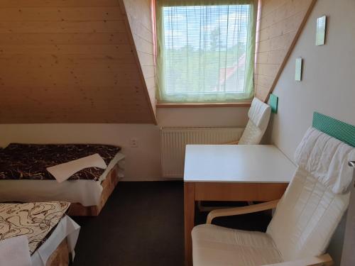 a room with two beds and a desk and a chair at Ubytování Benátky u Litomyšle in Litomyšl