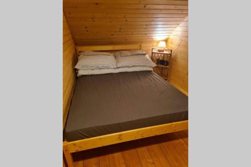 a bed in a wooden room with a bed in a cabin at Wapienne domek in Sękowa