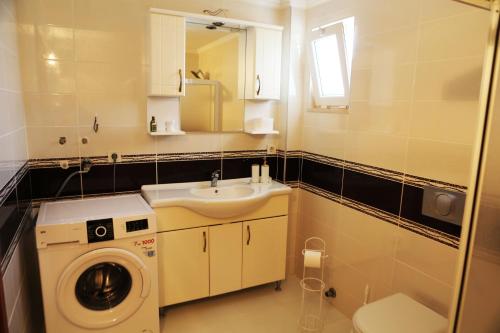 ein Badezimmer mit Waschmaschine und Waschbecken in der Unterkunft Kaş Güzey apart 3+1 Doğa ve deniz manzaralı in Kaş