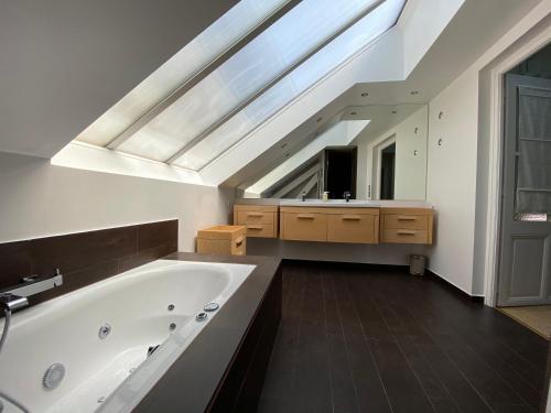 a bathroom with a large bath tub and a skylight at Elegant Duplex de Haut Standing de 230m2 in La Roche-sur-Foron