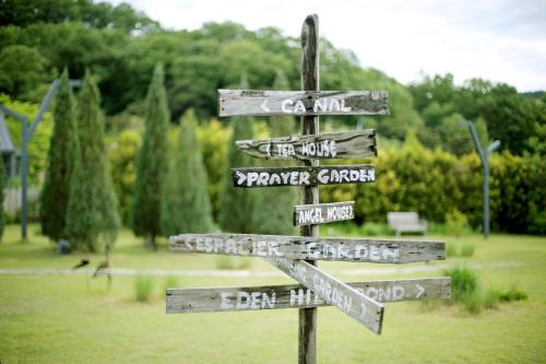a wooden sign with street signs in a park at Eden Paradise Hotel in Icheon