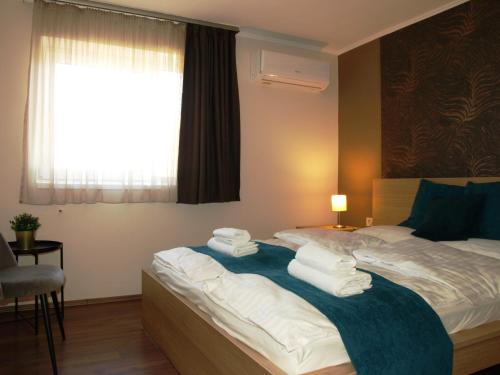 a bedroom with a bed with towels on it at Garden Club Panzió in Balatonmáriafürdő