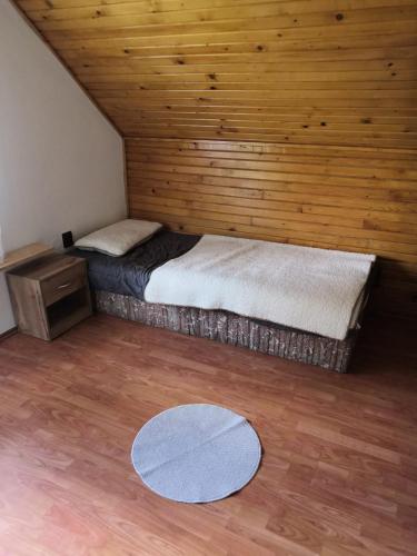 a room with two beds and a wooden wall at Ubytovanie u Božky in Dlhá nad Oravou