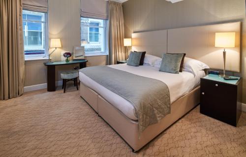 una camera d'albergo con un grande letto e una scrivania di Cheval Calico House a Londra