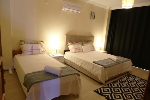 ein Hotelzimmer mit zwei Betten in einem Zimmer in der Unterkunft Kaş Güzey apart 3+1 Doğa ve deniz manzaralı in Kaş