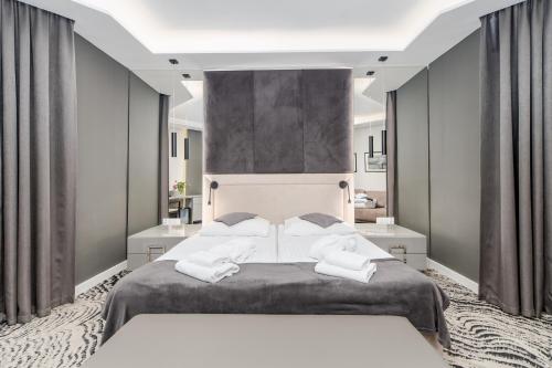 sypialnia z dużym łóżkiem i 2 białymi ręcznikami w obiekcie SeaPark Hotel Wellness & Spa w Kołobrzegu
