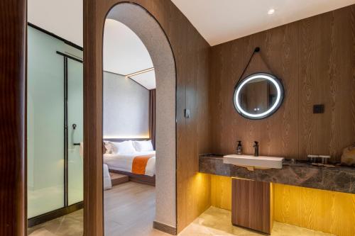 a bathroom with a sink and a bed at 洛阳Travel World Hotel in Luoyang