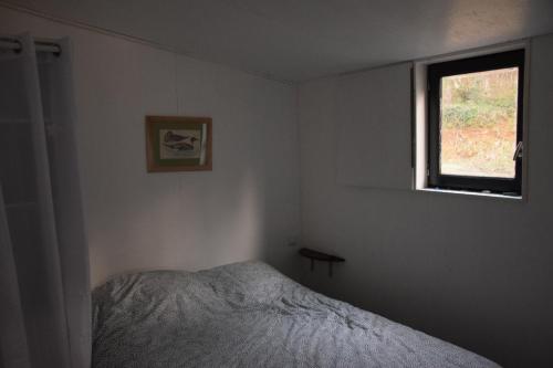 une chambre avec un lit et une fenêtre dans l'établissement bateau du moulin girault, à Panzoult