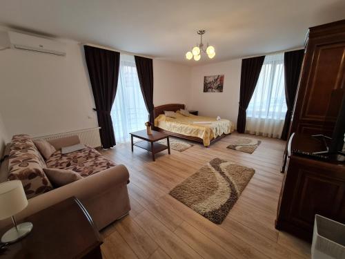 a living room with a bed and a couch at Select City Center in Târgu-Mureş