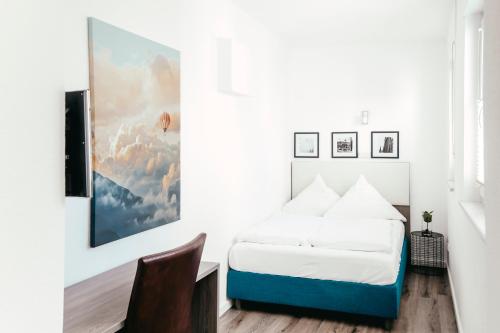 a bedroom with a bed and a painting on the wall at Haus am Dom - Apartments und Ferienwohnungen in Cologne