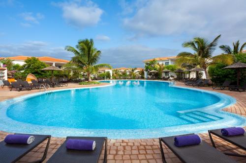 a swimming pool at a resort with chairs and palm trees at Melia Tortuga Beach - All Inclusive in Santa Maria
